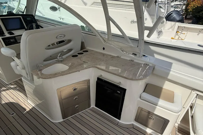 Slide: The Image of 2016 Sailfish 325 DC boat interior with sink, storage, and seating area. - 13