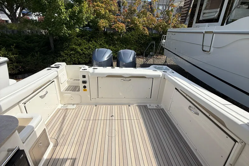 Slide: The Image of 2016 Sailfish 325 DC boat deck with twin engines, surrounded by greenery. - 17