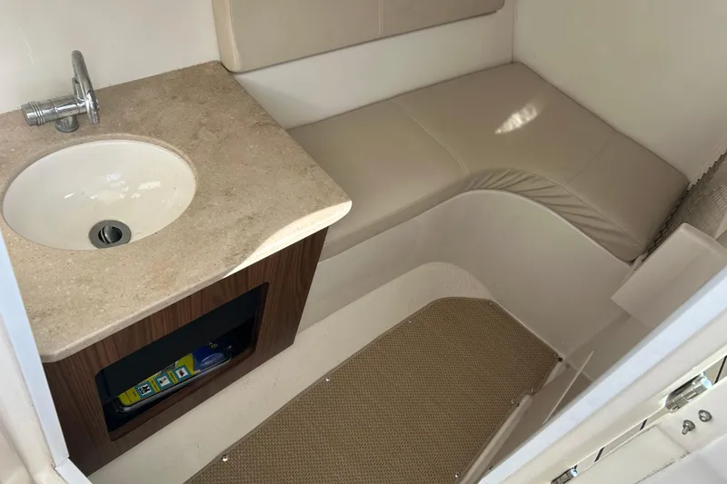 Slide: The Image of 2016 Sailfish 325 DC interior with sink and cushioned seating area. - 19