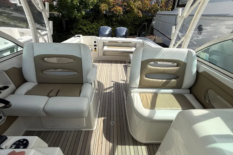 Slide: The Image of 2016 Sailfish 325 DC boat interior with beige and white seating, spacious deck. - 6