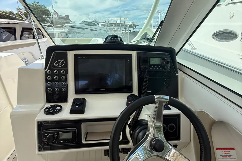 Slide: The Image of 2016 Sailfish 325 DC boat dashboard with steering wheel and navigation controls. - 7