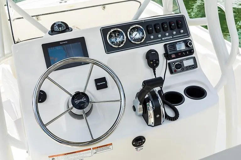 Slide: The Image of 2026 Boston Whaler 190 Montauk with Mercury outboard engine, docked outdoors. - 2