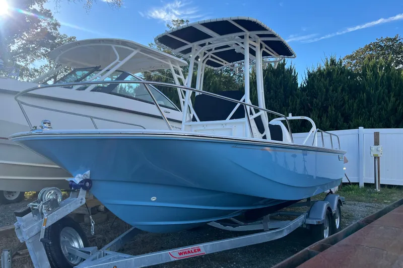 Slide: The Image of 2026 Boston Whaler 190 Montauk boat on trailer, blue hull, parked outdoors. - 20