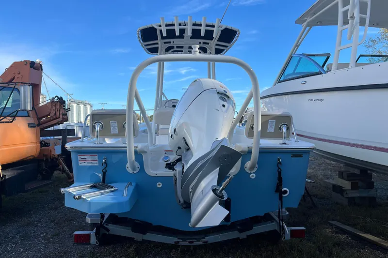 Slide: The Image of 2026 Boston Whaler 190 Montauk boat, rear view, with outboard motor and blue hull. - 22