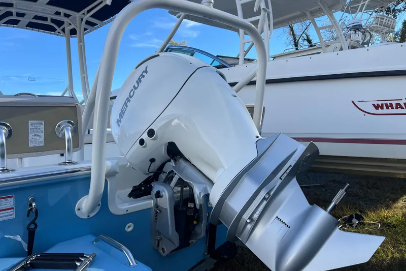 Slide: The Image of 2026 Boston Whaler 190 Montauk with Mercury outboard motor, docked under blue sky. - 23