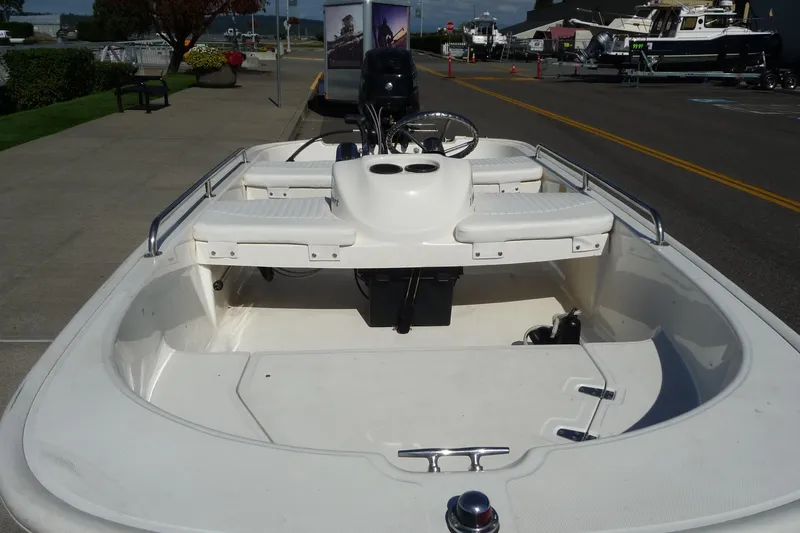 Slide: The Image of 2018 Boston Whaler 110 Sport boat, white interior, docked on a sunny day. - 9