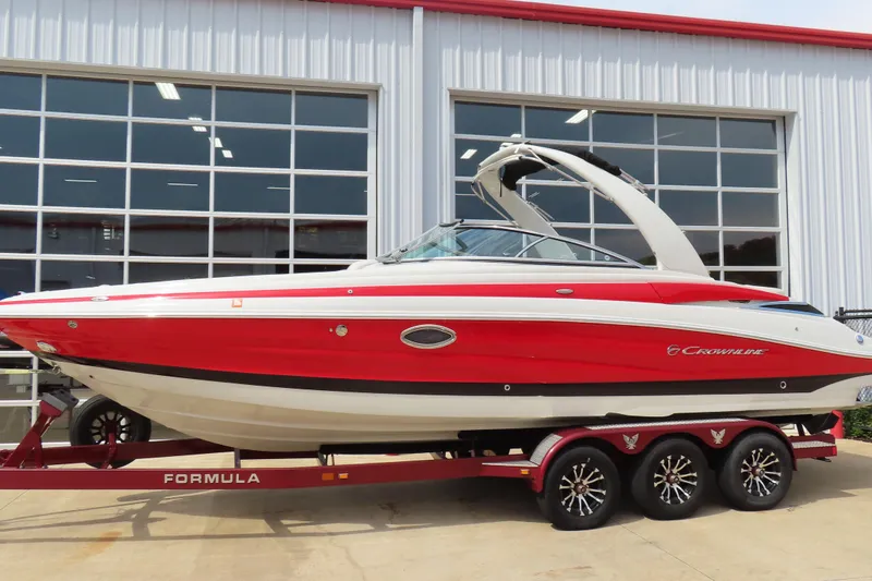 The Image of Red 2019 C 285ss boat on trailer, parked outside a garage. - 0