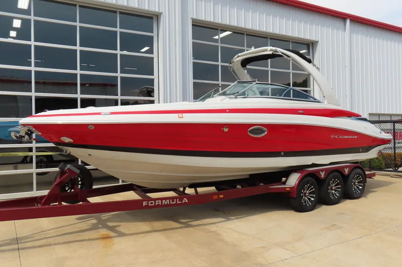 Slide: The Image of 2019 C 285ss boat on trailer, red and white design, parked outside a building. - 1
