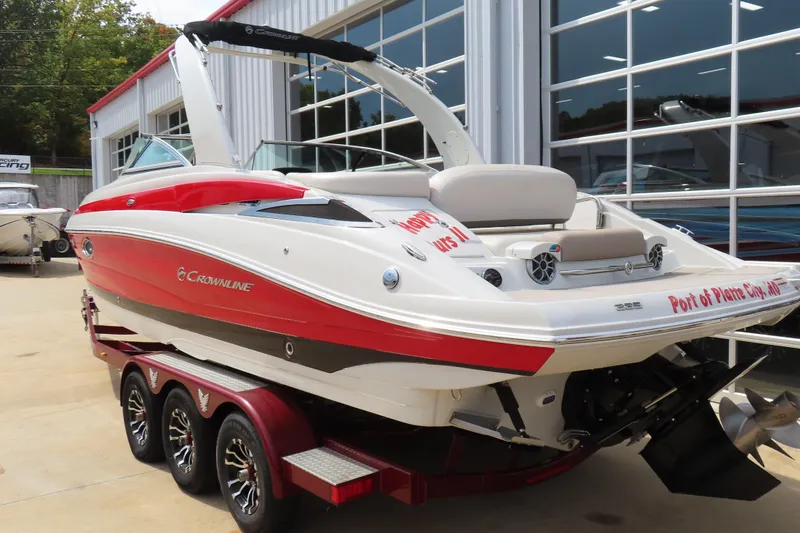 Slide: The Image of 2019 Crownline 285SS boat with red and white design on a trailer outside a showroom. - 4