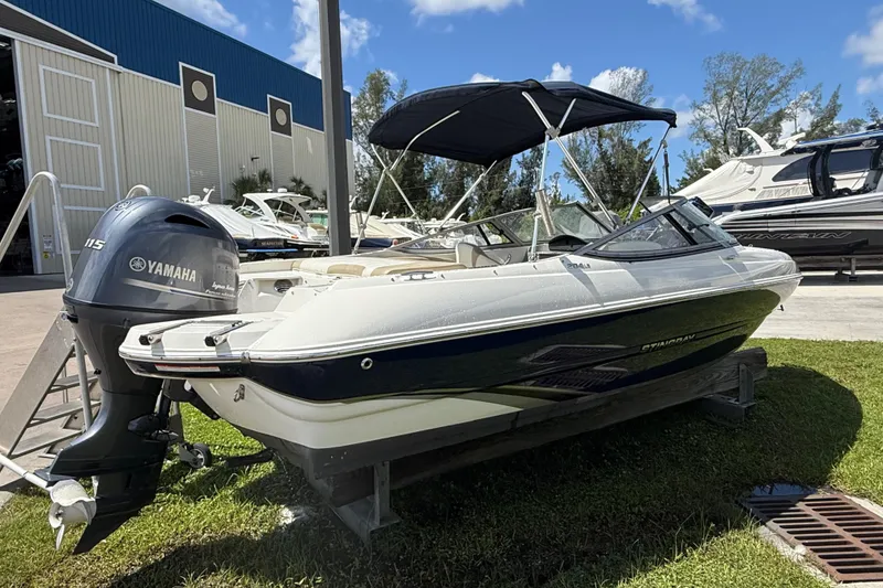 Slide: The Image of 2017 Stingray 204 LR boat with Yamaha engine, docked outdoors under blue sky. - 1