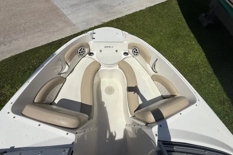 Slide: The Image of 2017 Stingray 204 LR boat interior with beige seating and cup holders. - 12