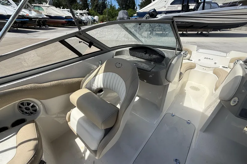 Slide: The Image of 2017 Stingray 204 LR boat interior with beige seating and dashboard. - 17