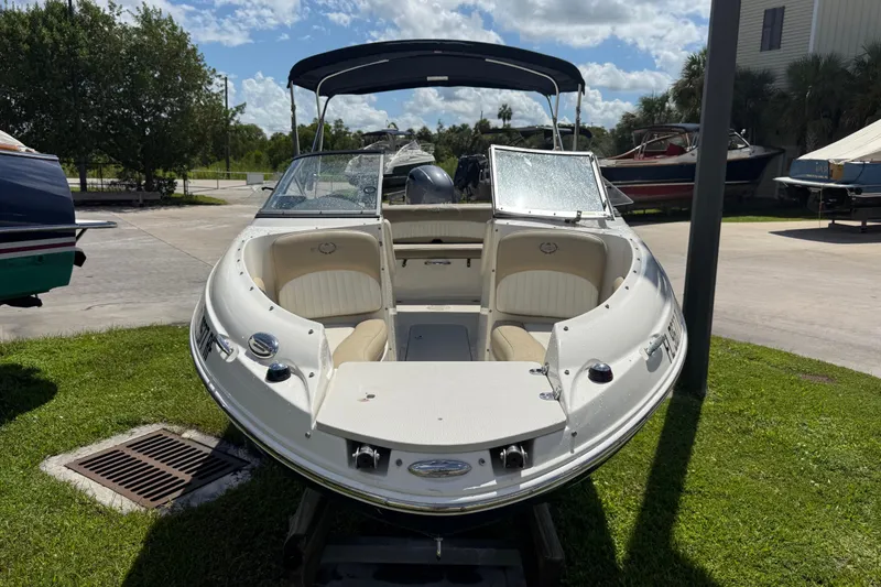 Slide: The Image of 2017 Stingray 204 LR boat with open bow seating, parked outdoors on grass. - 2