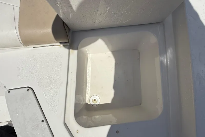 Slide: The Image of 2017 Stingray 204 LR boat interior with storage compartment and seating area. - 21