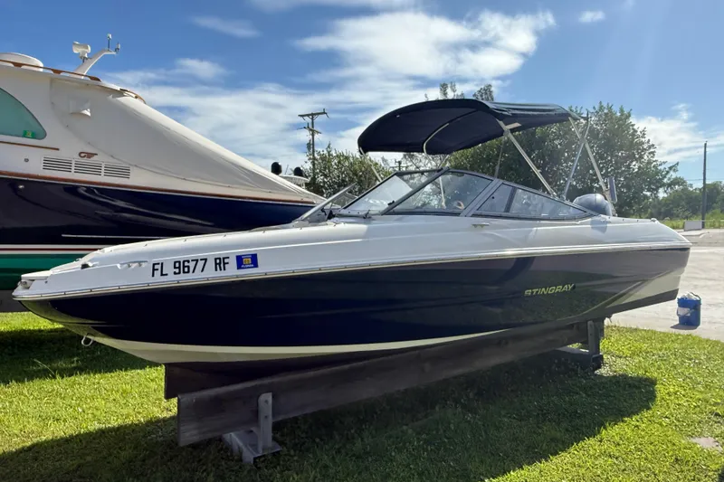 Slide: The Image of 2017 Stingray 204 LR boat on display, parked on grass under a clear sky. - 26