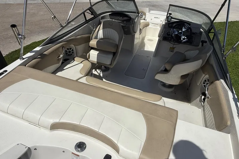 Slide: The Image of 2017 Stingray 204 LR boat interior with beige and white seating, steering wheel, and speakers. - 5