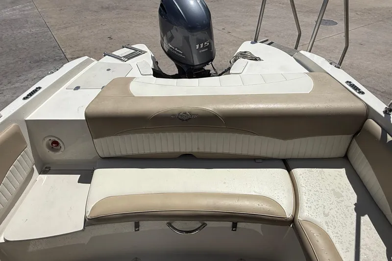 Slide: The Image of 2017 Stingray 204 LR boat interior with Yamaha 115 engine, featuring beige and white seating. - 7