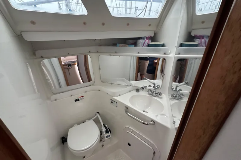 Slide: The Image of Compact bathroom in a 2000 Catalina 320 sailboat, featuring a toilet and sink. - 10