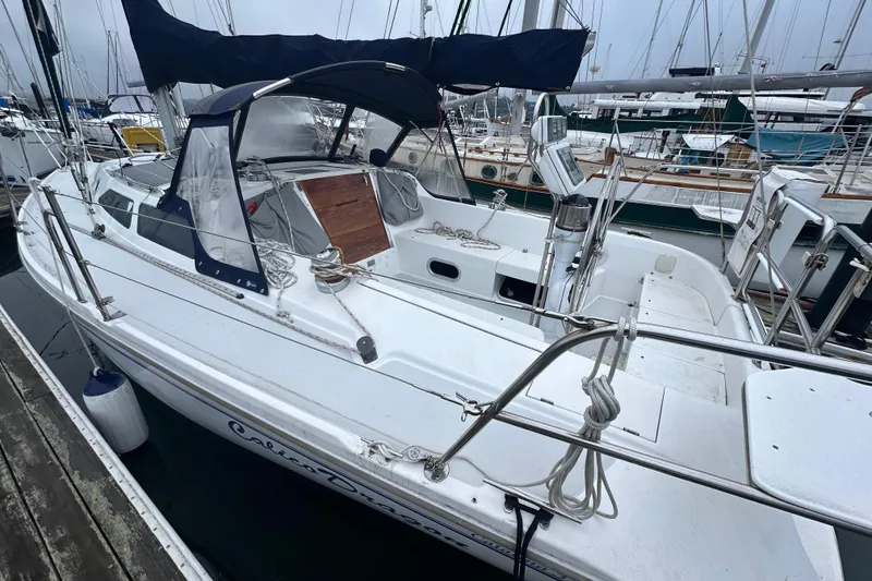 Slide: The Image of Catalina 320 sailboat from 2000 docked at marina, featuring spacious cockpit and canopy. - 3