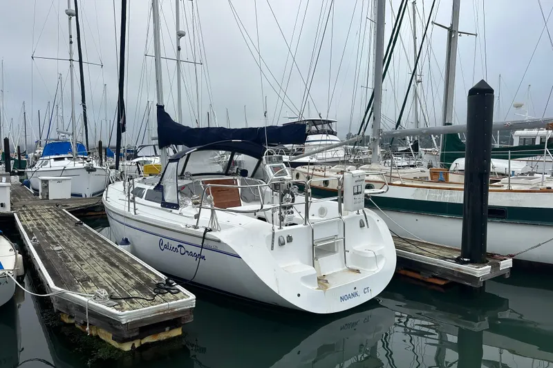 Slide: The Image of Sailboat Catalina 320, 2000 model, docked in a marina with overcast skies. - 5