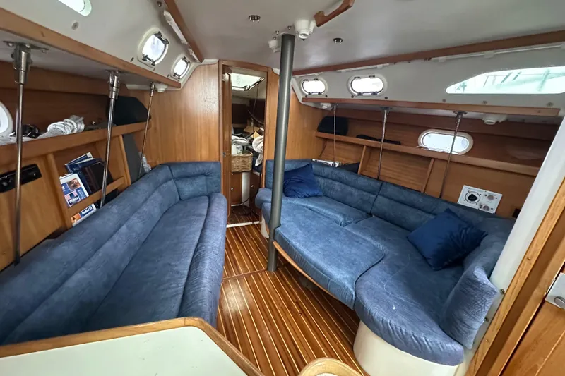 Slide: The Image of Interior of a 2000 Catalina 320 sailboat with blue seating and wooden accents. - 8