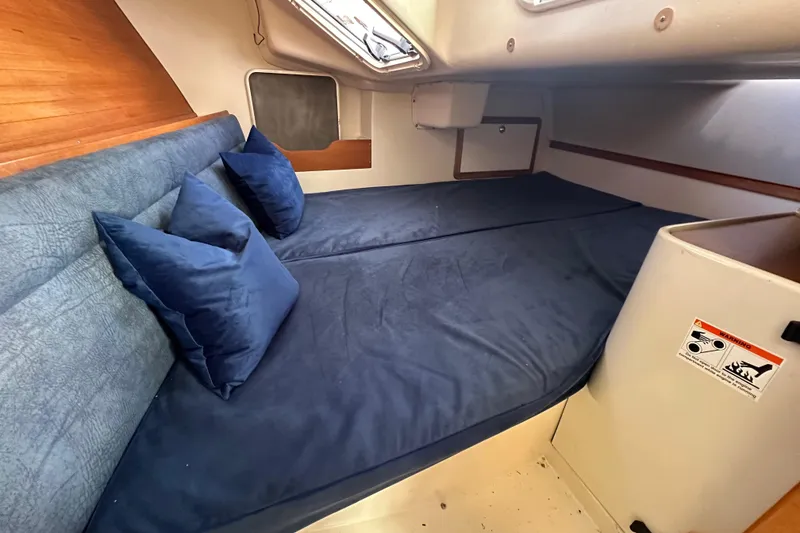 Slide: The Image of Interior cabin of a 2000 Catalina 320 sailboat with blue bedding and pillows. - 9