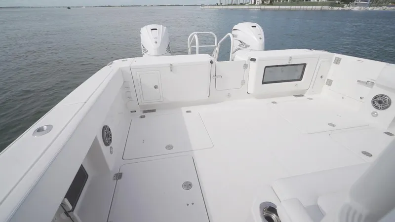 Slide: The Image of 2026 World Cat 400CC-X boat deck with dual engines, spacious layout, and ocean backdrop. - 23
