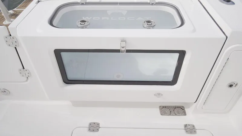 Slide: The Image of 2026 World Cat 400CC-X boat storage compartment with secure latches and transparent window. - 26