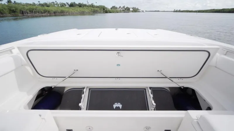 Slide: The Image of 2026 World Cat 400CC-X boat storage compartment open on calm water. - 31