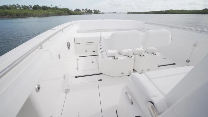 Slide: The Image of 2026 World Cat 400CC-X boat interior with white seating, cruising on a calm waterway. - 47