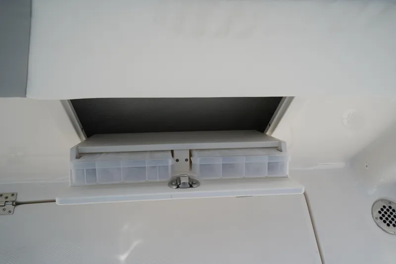 Slide: The Image of 2026 Robalo R250 Center Console storage compartment with organized tackle boxes. - 14