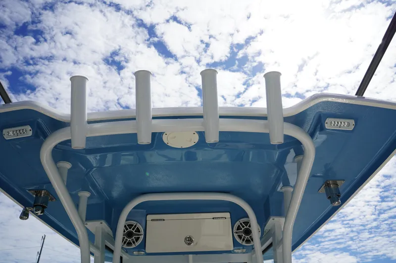 Slide: The Image of 2026 Robalo R250 Center Console boat top view with rod holders and speakers against cloudy sky. - 17