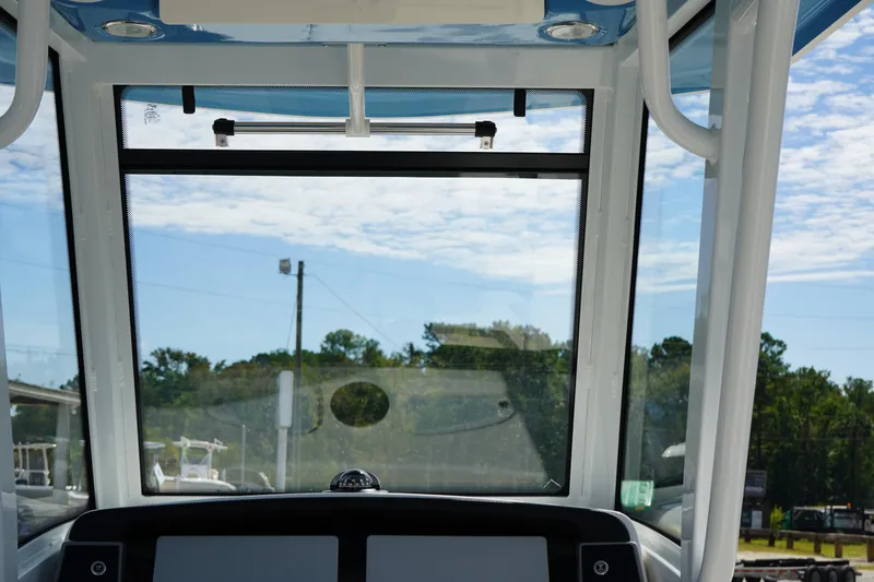 Slide: The Image of 2026 Robalo R250 Center Console boat interior with clear windshield and scenic view. - 19