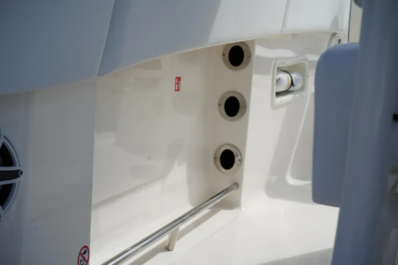 Slide: The Image of 2026 Robalo R250 Center Console boat interior detail with rod holders and speaker. - 34