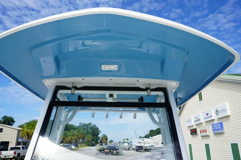 Slide: The Image of 2026 Robalo R250 Center Console boat with blue T-top under clear sky. - 38