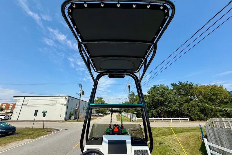 Slide: The Image of 2026 SCB R24 boat with T-top, street view, clear sky background. - 11