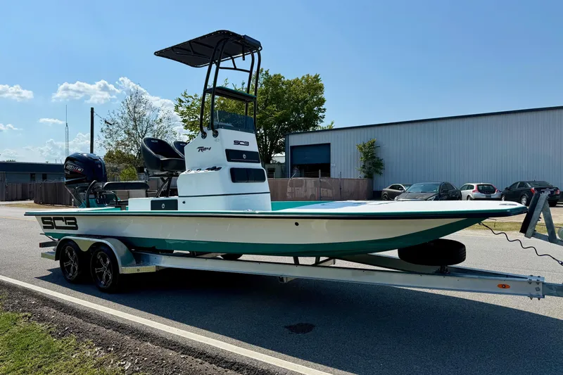 Slide: The Image of 2026 SCB R24 boat on trailer, parked outdoors near industrial building. - 5
