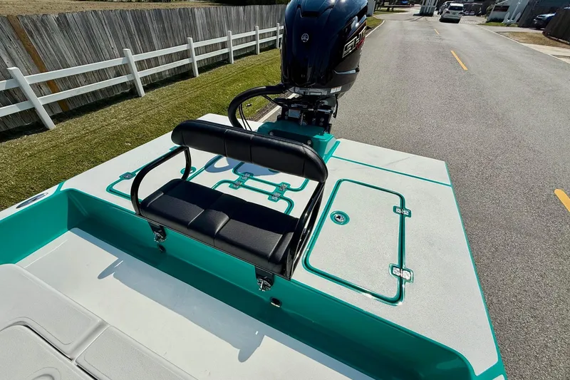 Slide: The Image of 2026 SCB R24 boat with black seating and outboard motor on a road. - 7