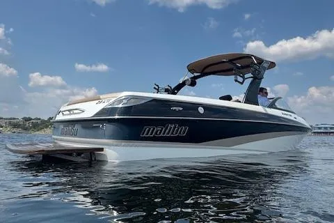 Slide: The Image of 2005 Malibu Sunsetter 23 XTi boat on calm water under blue sky. - 1
