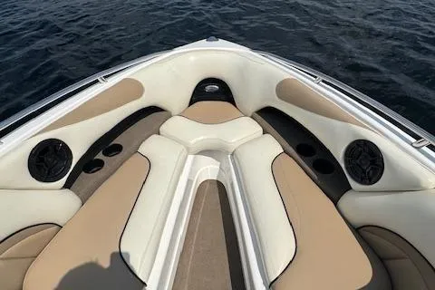 Slide: The Image of 2005 Malibu Sunsetter 23 XTi boat interior with beige and white seating, cup holders, and speakers. - 11