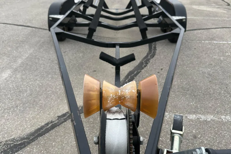 Slide: The Image of Trailer for 2005 Malibu Sunsetter 23 XTi boat, featuring a worn bow roller. - 16