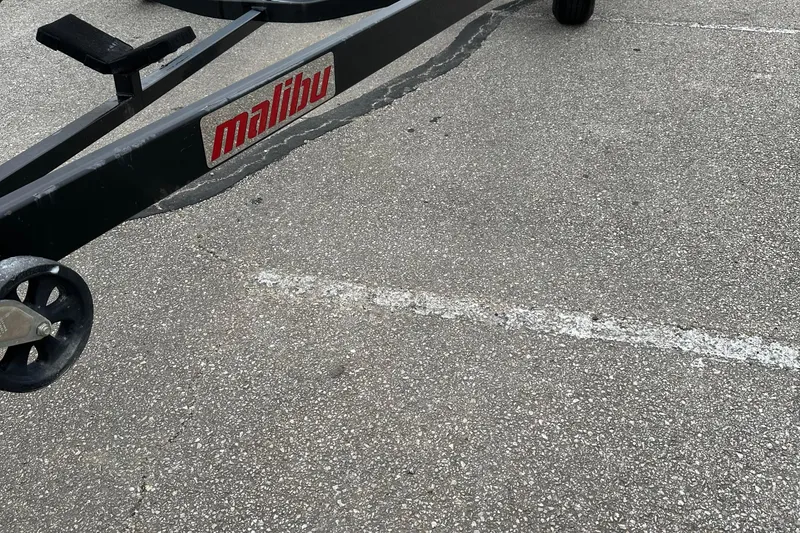 Slide: The Image of Trailer of a 2005 Malibu Sunsetter 23 XTi boat in a parking lot. - 17