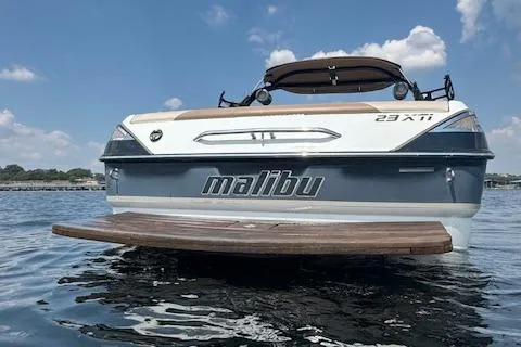 Slide: The Image of 2005 Malibu Sunsetter 23 XTi boat on water, rear view with swim platform. - 2