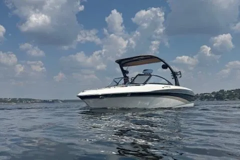 Slide: The Image of 2005 Malibu Sunsetter 23 XTi boat on a calm lake under a cloudy sky. - 3