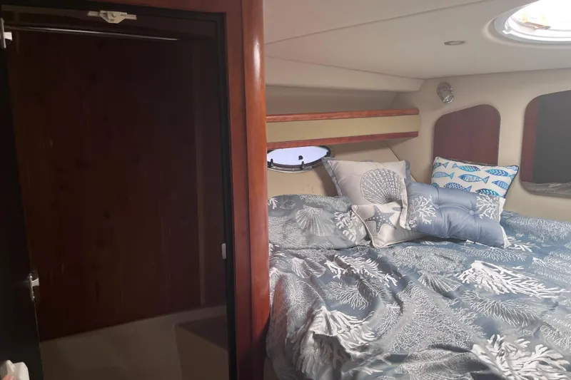 Slide: The Image of 2007 Cruisers Yachts 370 Express cabin with nautical-themed bedding and porthole window. - 20