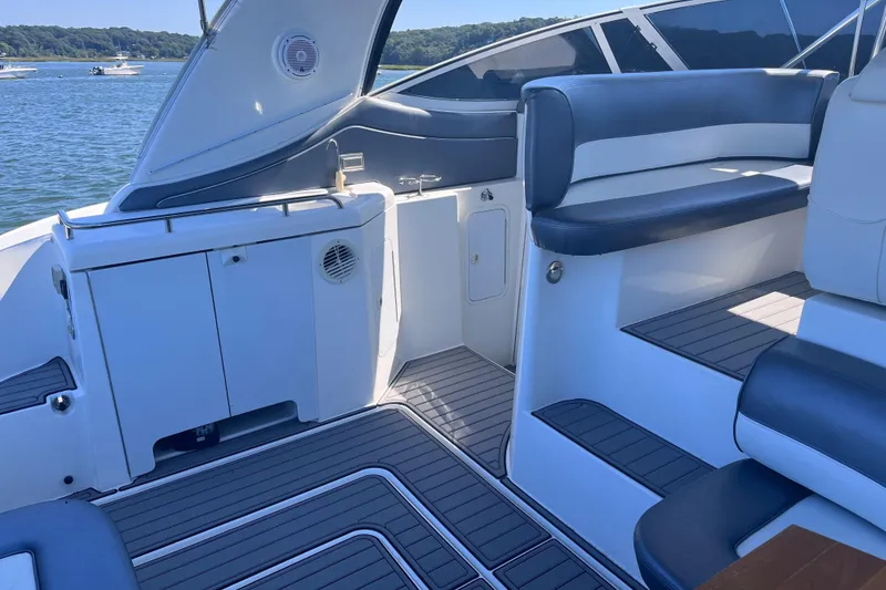 Slide: The Image of 2007 Cruisers Yachts 370 Express interior with seating and cabinetry, docked on a sunny day. - 9