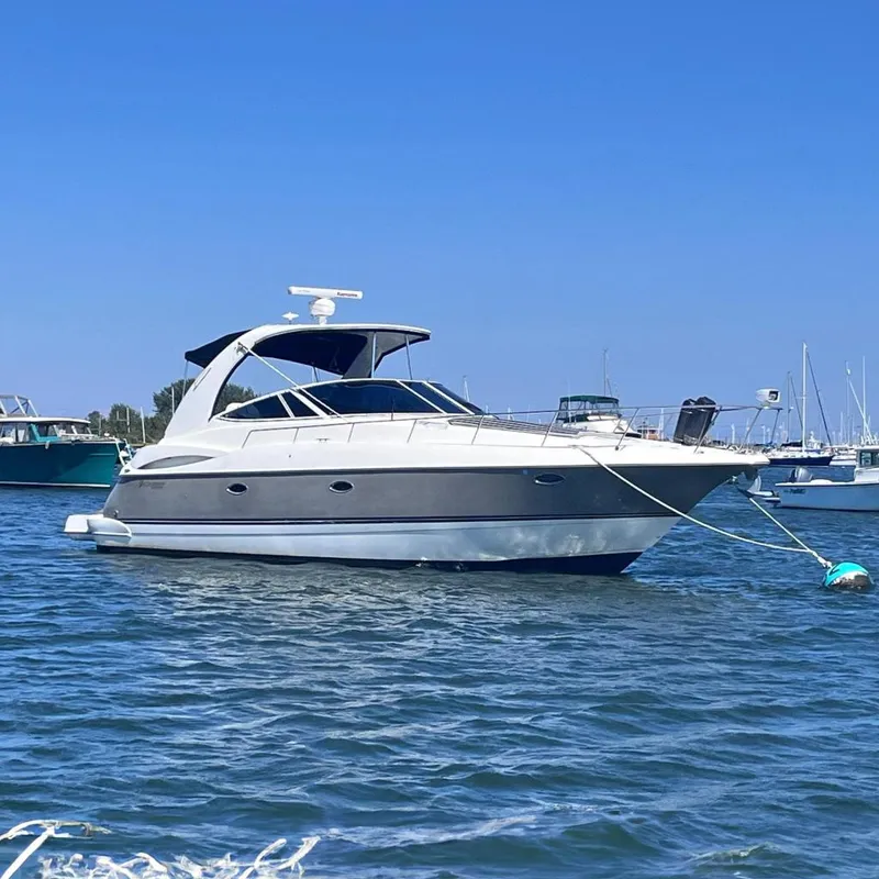 The Image of 2007 Cruisers Yachts 370 Express moored on calm water under clear blue sky. - 0