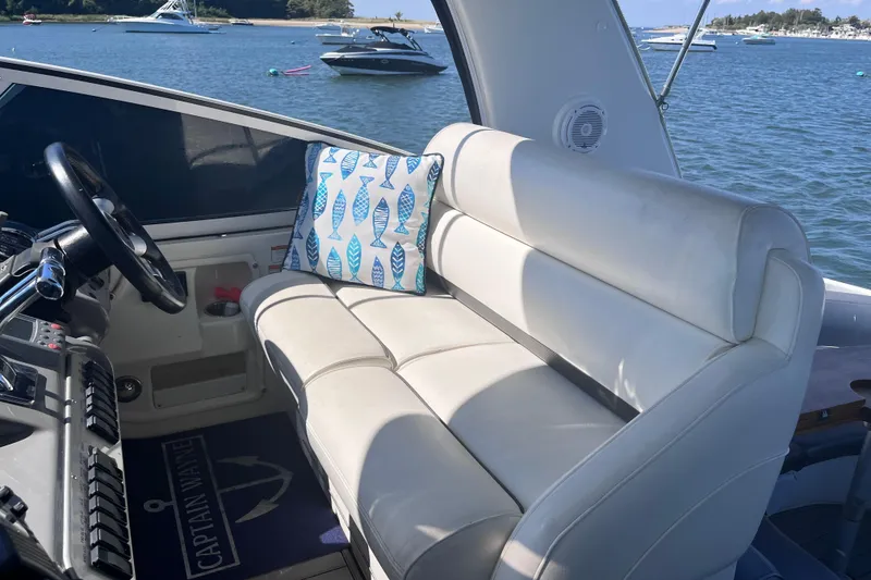 Slide: The Image of 2007 Cruisers Yachts 370 Express interior with white seating and nautical-themed pillow. - 12