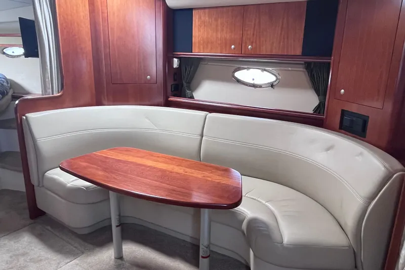Slide: The Image of 2007 Cruisers Yachts 370 Express interior with curved seating and wooden table. - 17