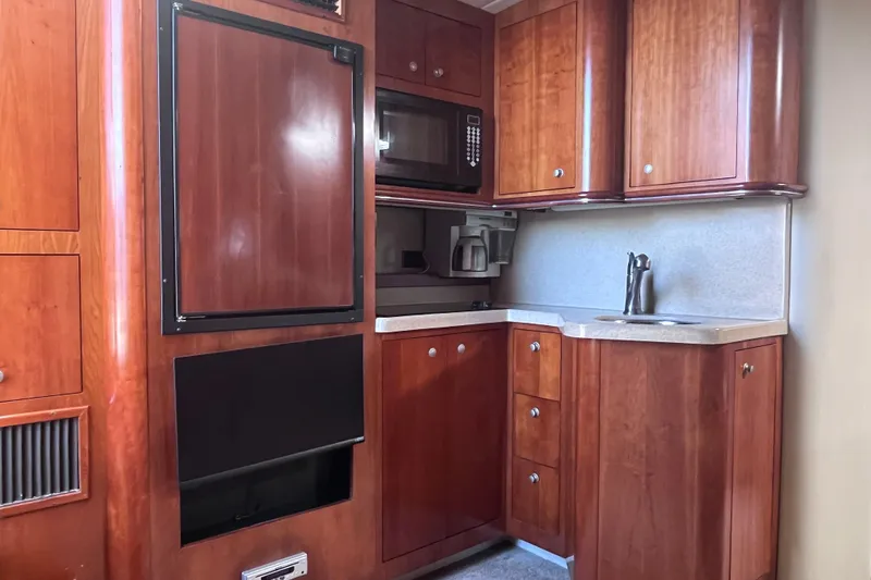 Slide: The Image of 2007 Cruisers Yachts 370 Express kitchen with wood cabinets, microwave, and sink. - 18